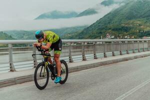 cheio comprimento retrato do a ativo triatleta dentro roupa de esporte e com uma protetora capacete equitação uma bicicleta. seletivo foco foto