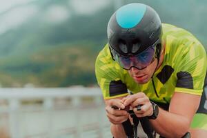 fechar acima foto do a ativo triatleta dentro roupa de esporte e com uma protetora capacete equitação uma bicicleta. seletivo foco