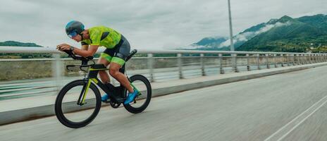 cheio comprimento retrato do a ativo triatleta dentro roupa de esporte e com uma protetora capacete equitação uma bicicleta. seletivo foco foto