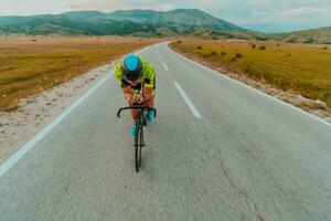 cheio comprimento retrato do a ativo triatleta dentro roupa de esporte e com uma protetora capacete equitação uma bicicleta. seletivo foco foto