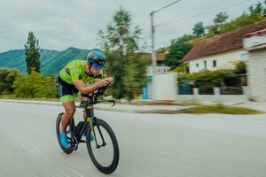 cheio comprimento retrato do a ativo triatleta dentro roupa de esporte e com uma protetora capacete equitação uma bicicleta. seletivo foco foto