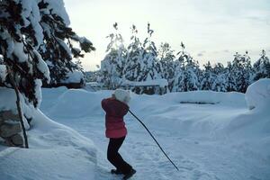 menina jogando neve fresca no lindo dia ensolarado de inverno foto