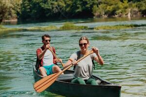 casal aventureiro explorador amigos estão canoagem dentro uma selvagem rio cercado de a lindo natureza foto