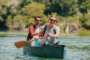 casal aventureiro explorador amigos estão canoagem dentro uma selvagem rio cercado de a lindo natureza foto