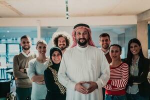 uma diverso grupo do bem sucedido o negócio pessoas dentro uma moderno vidro escritório ficar de pé juntos às a topo com seus árabe líder diretor foto