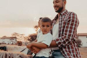 a família passa o tempo com seus filhos enquanto andam a cavalo juntos em uma praia de areia. foco seletivo foto