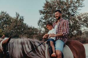 pai e filho gostam de andar a cavalo juntos à beira-mar. foco seletivo foto