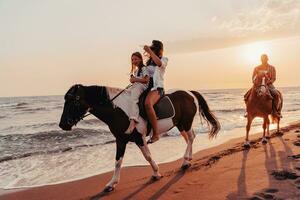 a família passa o tempo com seus filhos enquanto andam a cavalo juntos em uma praia de areia. foco seletivo foto