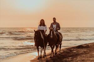 um casal apaixonado em roupas de verão, montando um cavalo em uma praia ao pôr do sol. mar e pôr do sol ao fundo. foco seletivo foto