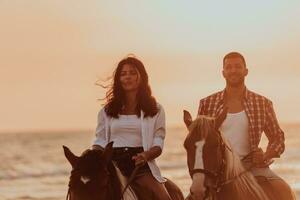 um casal apaixonado em roupas de verão, montando um cavalo em uma praia ao pôr do sol. mar e pôr do sol ao fundo. foco seletivo foto