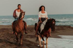 um casal apaixonado em roupas de verão, montando um cavalo em uma praia ao pôr do sol. mar e pôr do sol ao fundo. foco seletivo foto