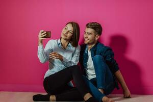 um jovem casal feliz sentado no chão em casa e fazendo selfie foto