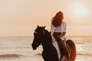 mulher com roupas de verão gosta de andar a cavalo em uma bela praia ao pôr do sol. foco seletivo foto