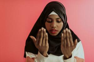 africano muçulmano mulher vestindo hijab e tradicional muçulmano roupas posando dentro frente do vermelho fundo foto