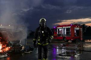 retrato do uma heróico bombeiro dentro uma protetora terno. bombeiro dentro fogo brigando ou carro acidente resgate Operação dentro crepúsculo ou noite. foto