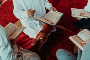 uma grupo do muçulmanos lendo a piedosos livro do a Alcorão dentro uma moderno mesquita durante a muçulmano feriado do Ramadã foto