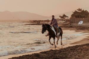 um homem moderno em roupas de verão gosta de andar a cavalo em uma bela praia ao pôr do sol. foco seletivo foto