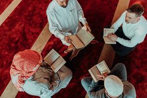 uma grupo do muçulmanos lendo a piedosos livro do a Alcorão dentro uma moderno mesquita durante a muçulmano feriado do Ramadã foto