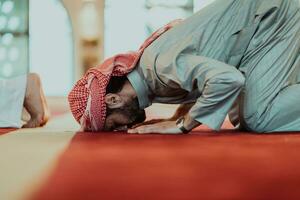 uma grupo do muçulmanos dentro uma moderno mesquita Rezar a muçulmano oração namaz, durante a piedosos mês do Ramadã foto