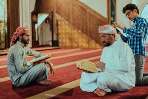 uma grupo do muçulmanos lendo a piedosos livro do a Alcorão dentro uma moderno mesquita durante a muçulmano feriado do Ramadã foto