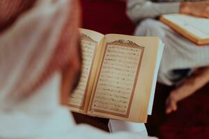 uma grupo do muçulmanos lendo a piedosos livro do a Alcorão dentro uma moderno mesquita durante a muçulmano feriado do Ramadã foto