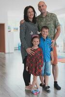 retrato do uma feliz família. foto do pais com crianças dentro uma moderno pré escola sala de aula. seletivo foco