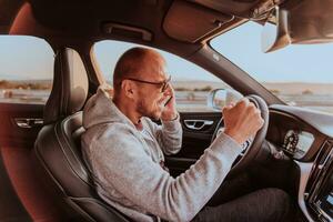 a motorista recebe feliz em formação enquanto falando em a Smartphone enquanto dirigindo a carro foto