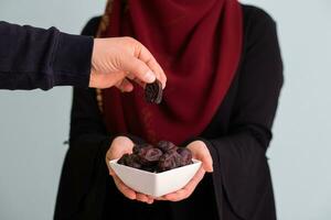 moderno muçulmano mulher segurando uma prato cheio do doce datas em iftar Tempo dentro Ramadã kareem islâmico saudável Comida conceito foto