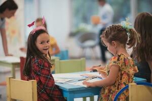 criativo crianças sentado dentro uma pré escola instituição, desenhar e ter Diversão enquanto elas pegue a Educação foto