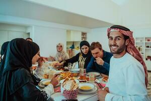 muçulmano família tendo iftar jantar bebendo água para pausa celebração. comendo tradicional Comida durante Ramadã festa mês às lar. a islâmico halal comendo e bebendo dentro moderno casa foto