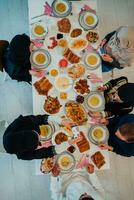 topo Visão do muçulmano família tendo iftar jantar bebendo água para pausa celebração. comendo tradicional Comida durante Ramadã festa mês às lar. a islâmico halal comendo e bebendo dentro moderno casa foto