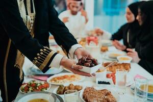 muçulmano família tendo iftar jantar bebendo água para pausa celebração. comendo tradicional Comida durante Ramadã festa mês às lar. a islâmico halal comendo e bebendo dentro moderno casa foto