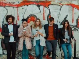 jovens ficam em frente a um muro desenhado em uma rua abandonada. foto