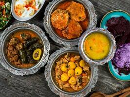 eid Mubarak tradicional Ramadã iftar jantar. sortido saboroso Comida dentro autêntico rústico pratos em de madeira azul fundo. turco bósnio Comida carne Churrasquinho, Pão Pita, sarma, klepe, sogan dolma. foto