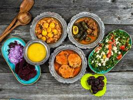 eid Mubarak tradicional Ramadã iftar jantar. sortido saboroso Comida dentro autêntico rústico pratos em de madeira azul fundo. turco bósnio Comida carne Churrasquinho, Pão Pita, sarma, klepe, sogan dolma. foto