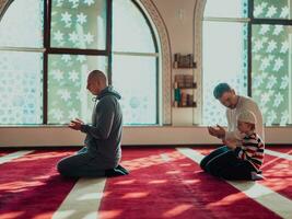 uma grupo do muçulmanos dentro uma moderno mesquita Rezar a muçulmano oração namaz, durante a piedosos mês do Ramadã foto