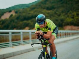 cheio comprimento retrato do a ativo triatleta dentro roupa de esporte e com uma protetora capacete equitação uma bicicleta. seletivo foco foto