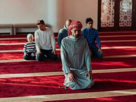 uma grupo do muçulmanos dentro uma moderno mesquita Rezar a muçulmano oração namaz, durante a piedosos mês do Ramadã foto