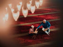 oração muçulmana pai e filho na mesquita orando e lendo o livro de azevinho alcorão juntos conceito de educação islâmica foto