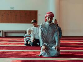 uma grupo do muçulmanos dentro uma moderno mesquita Rezar a muçulmano oração namaz, durante a piedosos mês do Ramadã foto