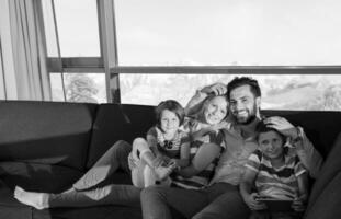 feliz casal jovem passar tempo com crianças em casa foto