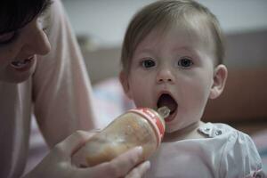 pequeno bebê bebendo suco a partir de garrafa foto