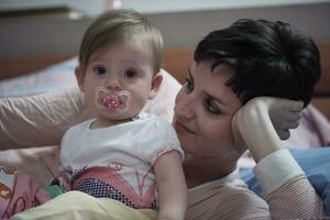 mãe está brincando com bebê em casa foto