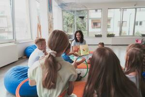 lendo Tempo dentro a elementar escola ou Jardim da infância, uma professor lê uma livro para crianças dentro a elementar escola ou Jardim da infância. a conceito do pré escola Educação. seletivo foco foto