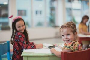 criativo crianças sentado dentro uma pré escola instituição, desenhar e ter Diversão enquanto elas pegue a Educação foto