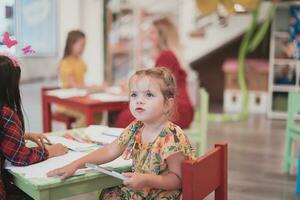 criativo crianças sentado dentro uma pré escola instituição, desenhar e ter Diversão enquanto elas pegue a Educação foto