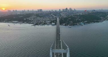 Istambul bósforo ponte e cidade Horizonte dentro fundo com turco bandeira às lindo pôr do sol, aéreo deslizar órbita e rastreamento tiro foto