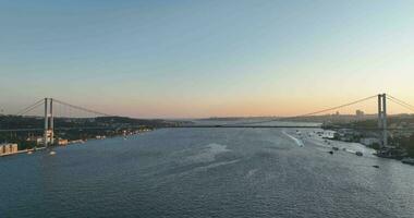 Istambul bósforo ponte e cidade Horizonte dentro fundo com turco bandeira às lindo pôr do sol, aéreo deslizar órbita e rastreamento tiro foto