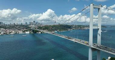 Istambul bósforo ponte e cidade Horizonte dentro fundo com turco bandeira às lindo pôr do sol, aéreo deslizar órbita e rastreamento tiro foto