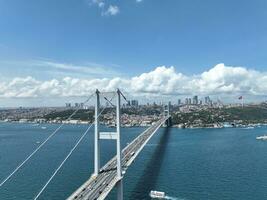 Istambul bósforo ponte e cidade Horizonte dentro fundo com turco bandeira às lindo pôr do sol, aéreo deslizar órbita e rastreamento tiro foto